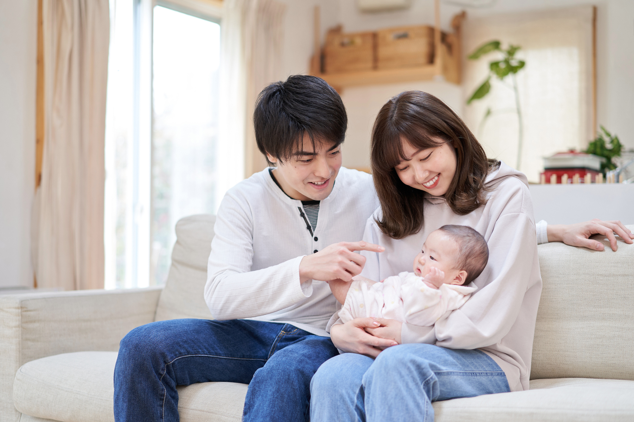 Young Asian parents holding their surrogate baby after facing infertility.