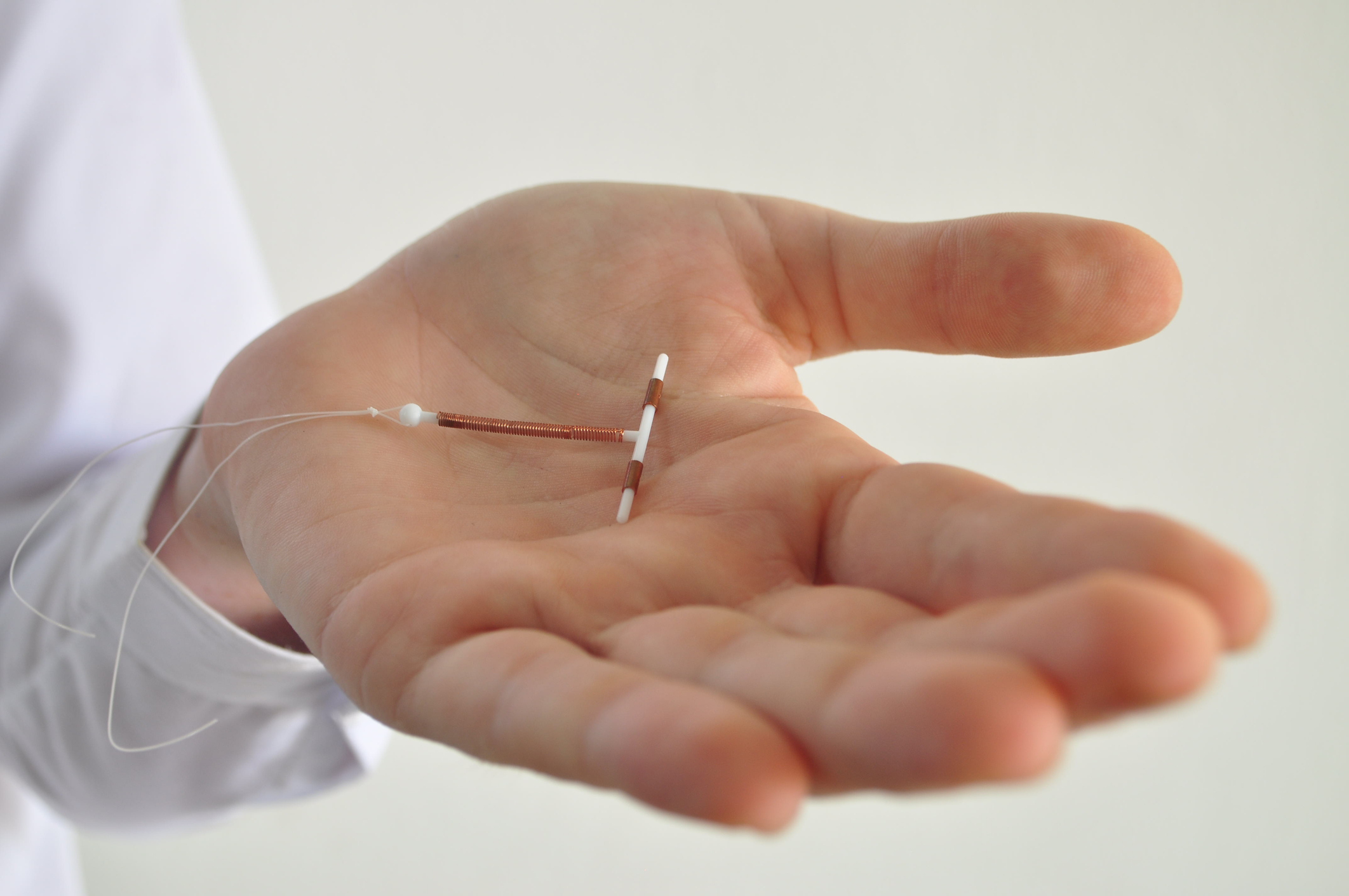 Doctor holds an IUD as she explains whether or not an IUD can cause infertility.
