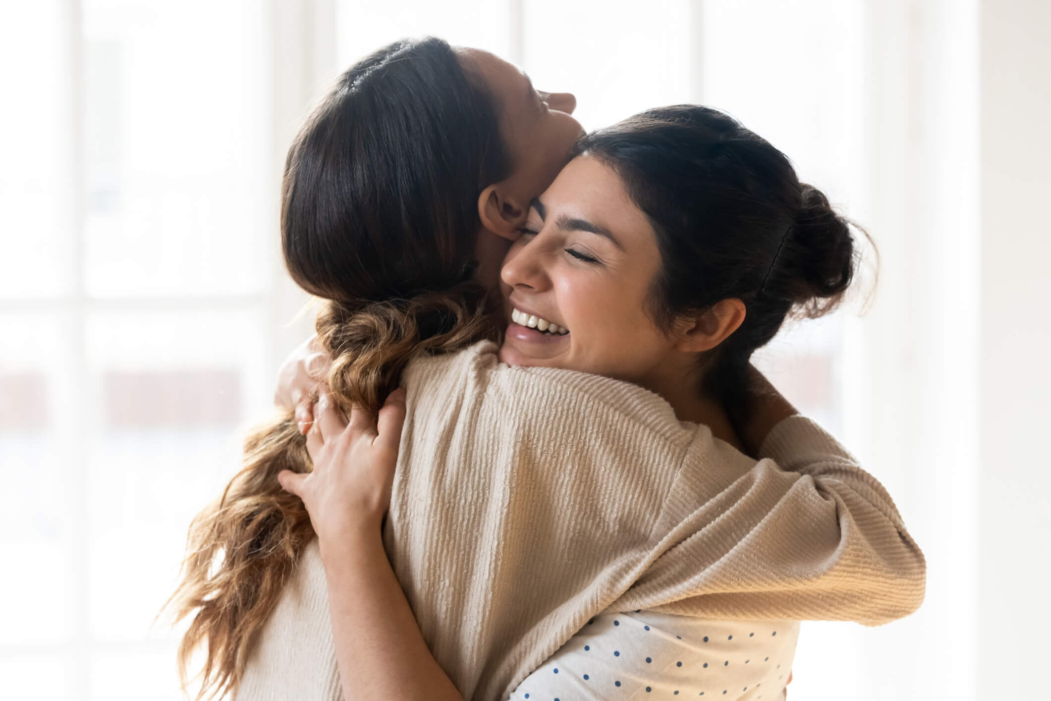 Woman hugs her sister after deciding to be her surrogate. The surrogacy cost of using a family member can help families build their family.